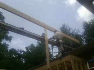 Carpenter setting a ridge beam over a new addition frame — Ice Dam Removal by Roofing Brothers in Medaryville