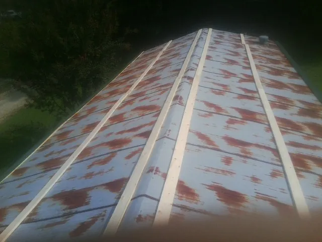 Rusted metal roof panels with new wood purlins before replacement — Storm Damage Roof Repair in Medaryville by Roofing Brothers
