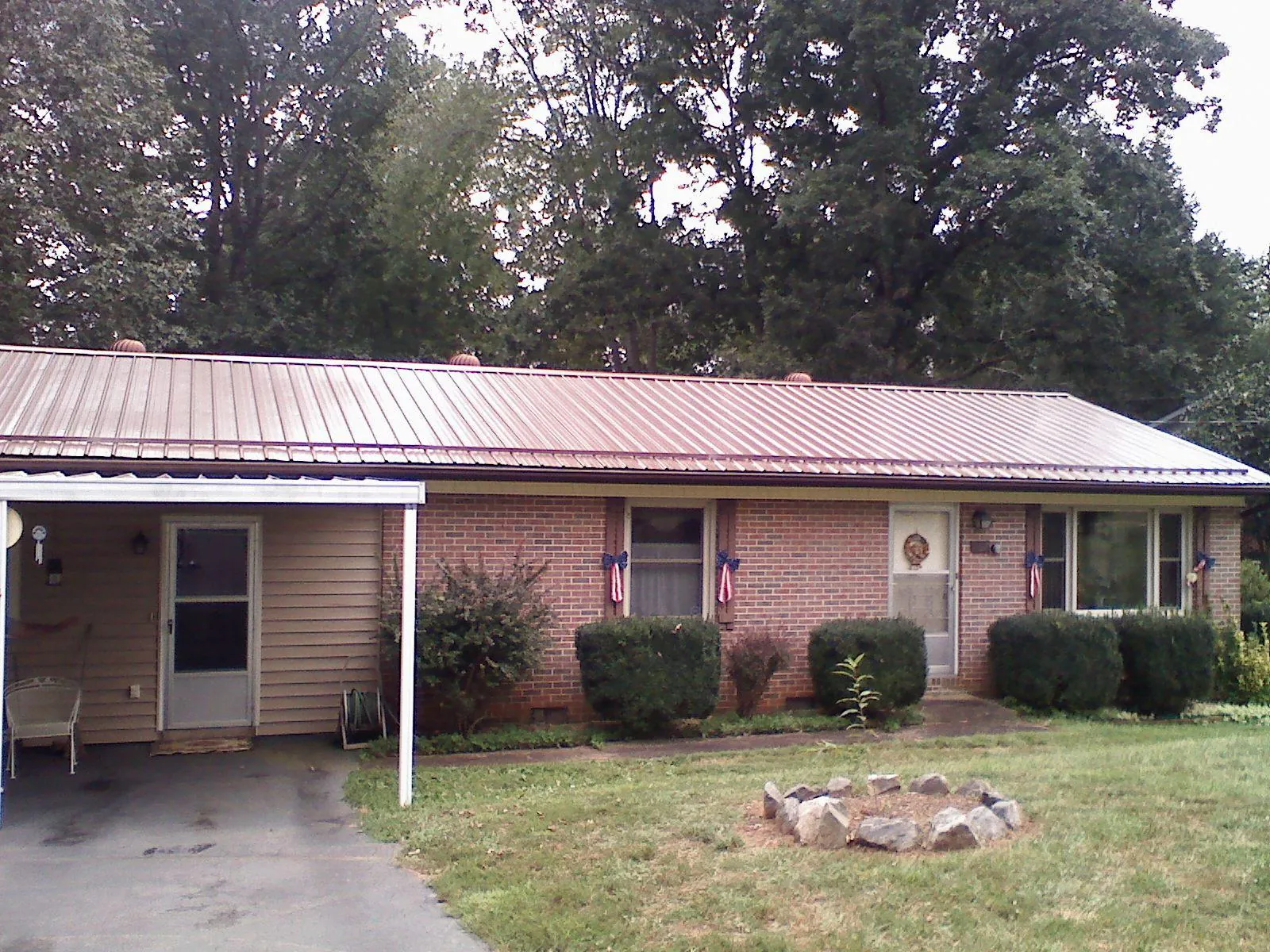 Bronze metal roof and carport on a brick ranch home — Roof Repair work by our crew in Medaryville